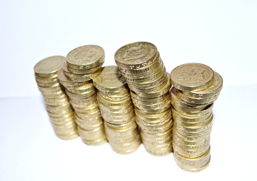 Koin emas bertumpuk melambangkan bonus selamat datang